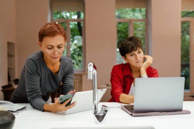 Evde mutfaktayken aletler kullanan olgun lezbiyen çift.