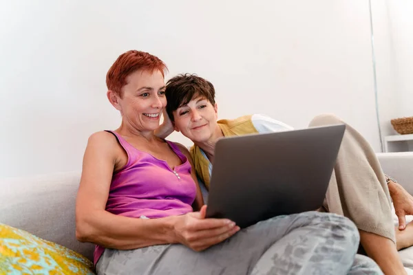 Starší Lesbičky Pár Pomocí Notebooku Při Odpočinku Pohovce Společně Doma — Stock fotografie