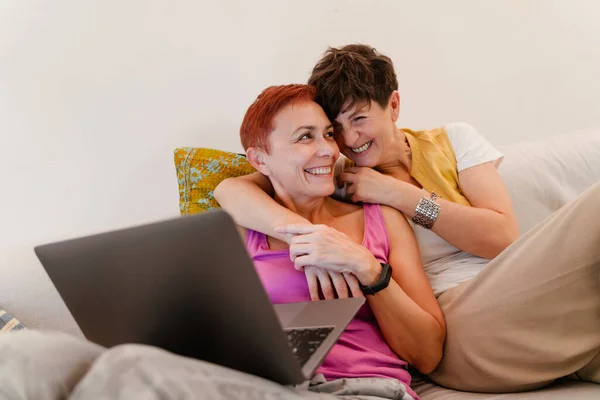 Starší Lesbičky Pár Objímání Používání Notebooku Pohovce Doma — Stock fotografie