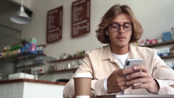 Homem Loiro Feliz Óculos Mensagens Texto Por Celular Café — Vídeo de Stock