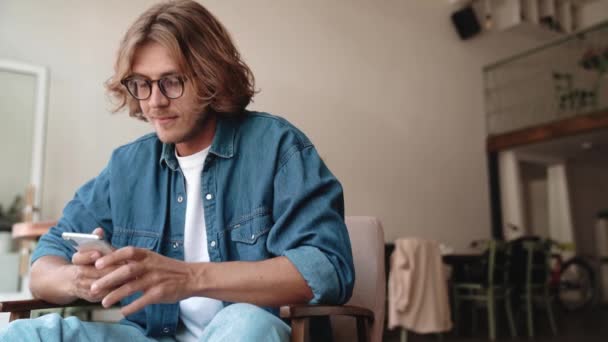 Cheerful Blond Man Eyeglasses Texting Phone Cafe — Stock Video