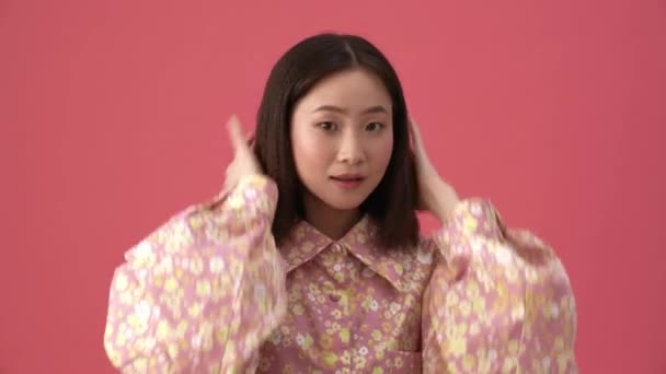 Yakışıklı Asyalı Kadın Pembe Stüdyoda Saç Stilini Düzeltiyor — Stok video