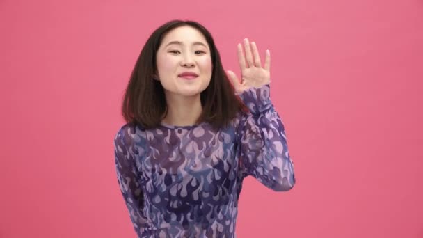 Gülümseyen Asyalı Kadın Pembe Stüdyoda Hoşça Kal Diyor — Stok video