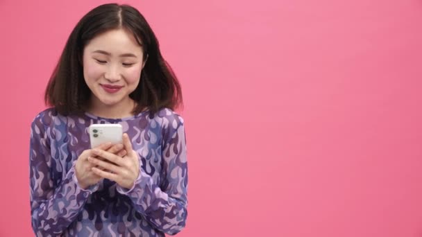 Pembe Stüdyoda Cep Telefonunda Yazan Güzel Asyalı Kadın — Stok video