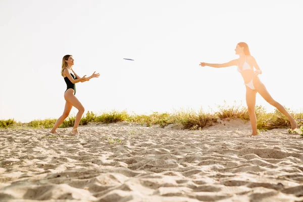 Молоді Дві Жінки Посміхаються Граючи Фрібі Пляжі Разом — стокове фото
