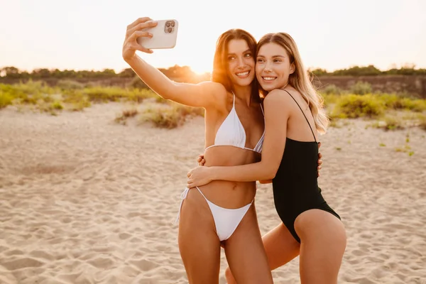 Fiatal Fehér Nők Mosolyognak Miközben Szelfi Fotót Készítenek Mobiltelefonon Strandon — Stock Fotó
