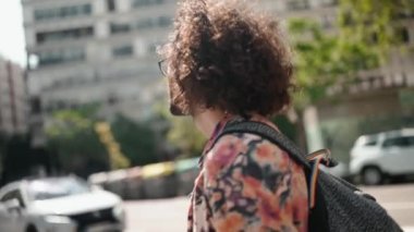 Güzel kıvırcık saçlı, gözlüklü, dışarıda meyve suyuyla yürüyen sakallı adam.