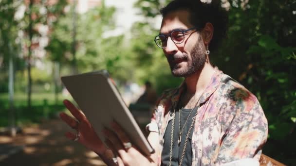 Pozitif Kıvırcık Saçlı Gözlüklü Dışarıda Bankta Otururken Tablete Bakan Sakallı — Stok video