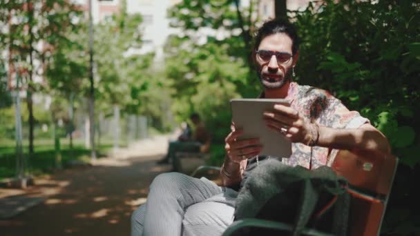 Poważny Kręcone Włosy Brodaty Mężczyzna Okularach Patrząc Tabletkę Podczas Siedzenia — Wideo stockowe