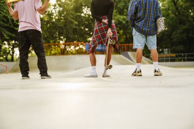 Beyaz gençler kaykay tutarken kaykay parkında vakit geçiriyorlar.