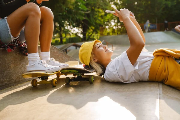 Asiatisk Flicka Skrattar Och Använder Mobiltelefon När Ligger Skate Park — Stockfoto