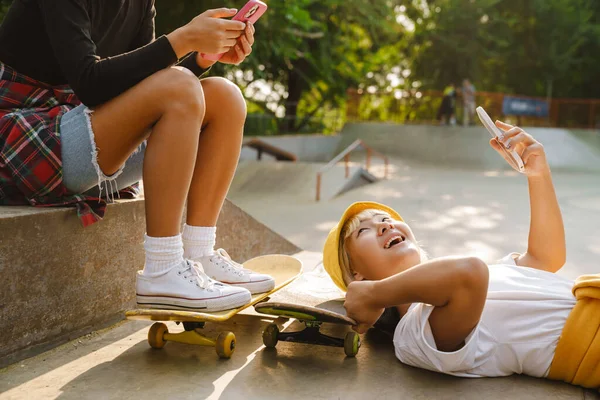 Multiracial Flickor Som Använder Mobiltelefoner Medan Tillbringar Tid Skate Park — Stockfoto