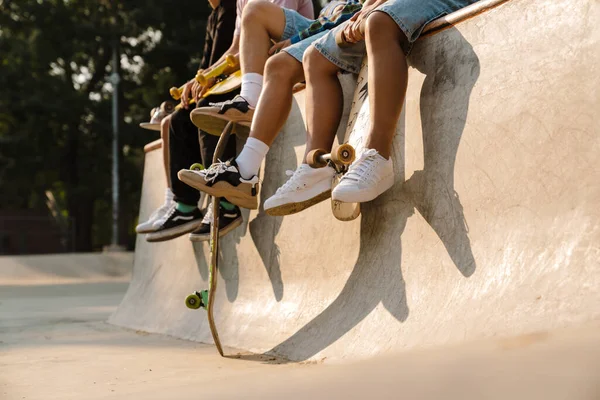 Cuatro Adolescentes Sentados Con Sus Patinetas Mientras Pasan Tiempo Parque —  Fotos de Stock