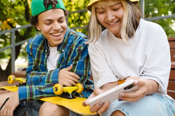 Dois Adolescentes Multirraciais Sorrindo Usando Celular Enquanto Passam Tempo Parque — Fotografia de Stock