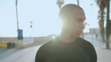 Pozitif kel sporcu sabahları kameraya bakıyor.