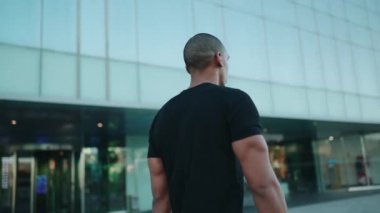 Kel sporcu siyah tişört giyiyor ve sabah dışarı çıkıyor.