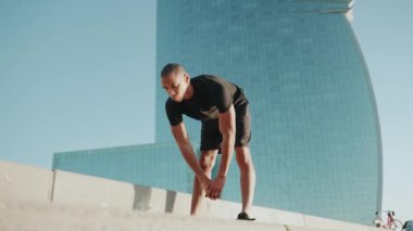 Ciddi kel sporcu siyah tişört giyiyor ve sabahları dışarı çıkıyor.