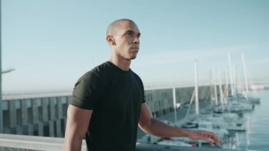 Kel yakışıklı sporcu siyah tişört giyiyor ve sabah dışarı çıkıyor.