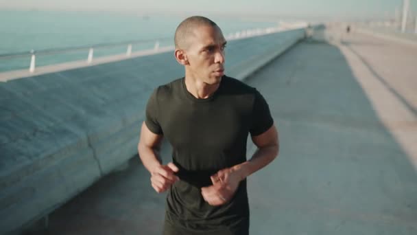 午前中に屋外で走っている黒のTシャツを着たペンシャルハゲスポーツマン — ストック動画