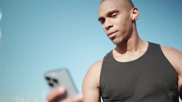 Καραφλός Ευχαριστημένος Αθλητής Φορώντας Μαύρο Shirt Πληκτρολογώντας Στο Τηλέφωνο Εξωτερικούς — Αρχείο Βίντεο