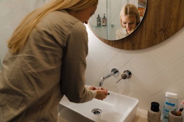 Banyoda yıkanırken gülümseyen genç sarışın kadın.