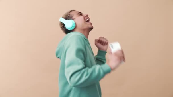 Hombre Rizado Sonriente Con Capucha Azul Cantando Bailando Auriculares Estudio — Vídeo de stock