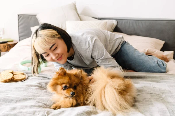 Aziatisch Meisje Aaien Haar Gember Hond Terwijl Rusten Bed Thuis — Stockfoto