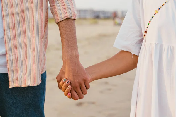 夏のビーチを歩きながら手をつなぐ多人種カップル — ストック写真