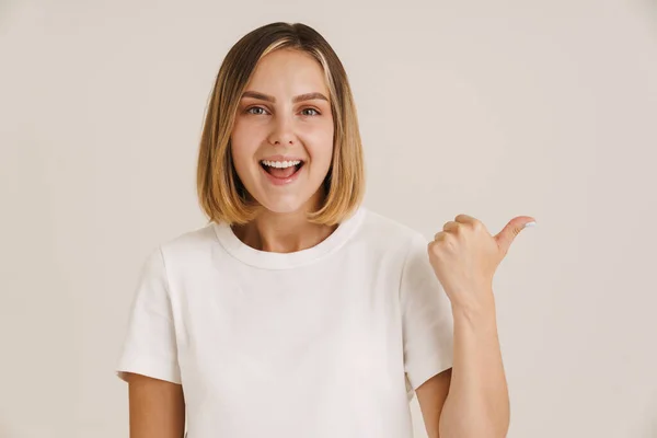 Joven Mujer Rubia Sonriendo Mientras Señala Con Dedo Lado Aislado —  Fotos de Stock