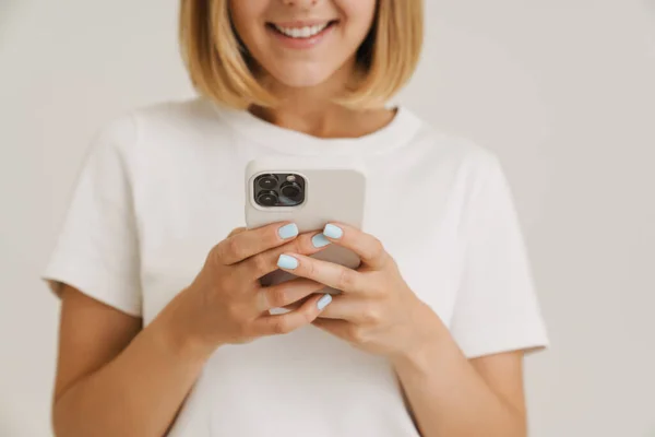 Молода Блондинка Посміхається Під Час Використання Мобільного Телефону Ізольовано Білому — стокове фото