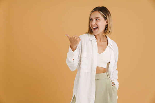 Young Blonde Woman Laughing While Pointing Finger Aside Isolated Beige Royalty Free Stock Photos