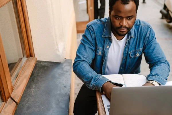Fekete Fiatalember Dolgozik Laptop Miközben Kávézó Szabadban — Stock Fotó