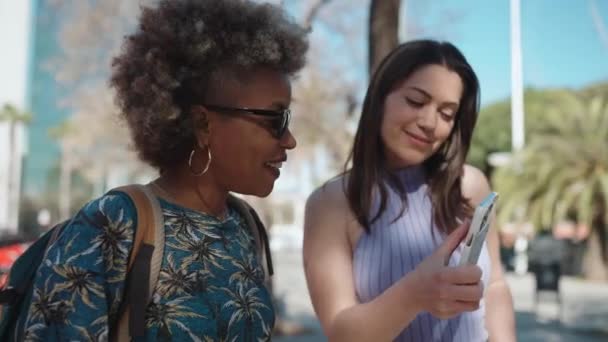 Two Pleased Multiethnic Women Talking Looking Mobile Outdoors — Stock Video