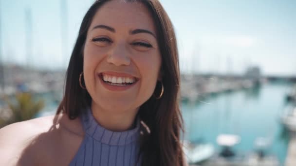 Mujer Morena Sonriente Mostrando Ciudad Cámara Mientras Está Pie Terraplén — Vídeos de Stock