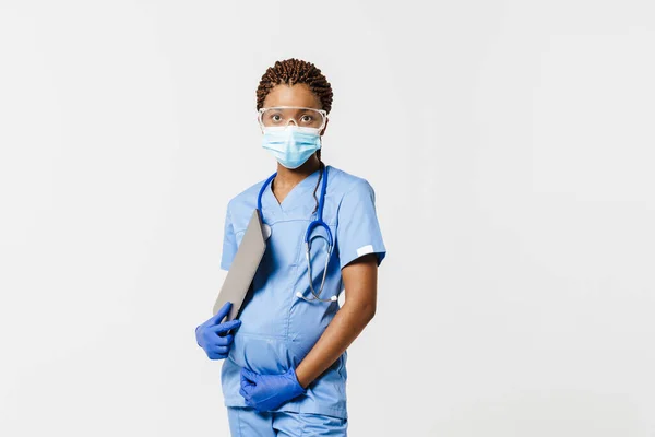 黒妊娠中の医者で顔マスクPosingとともにラップトップ絶縁上の白い背景 — ストック写真