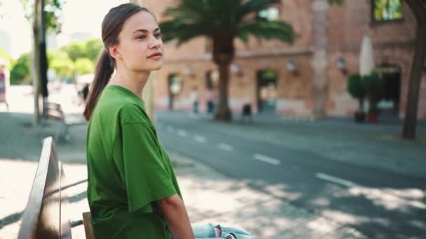 Όμορφη Ξανθιά Γυναίκα Φοράει Πράσινο Μπλουζάκι Κάθεται Στον Πάγκο Στην — Αρχείο Βίντεο