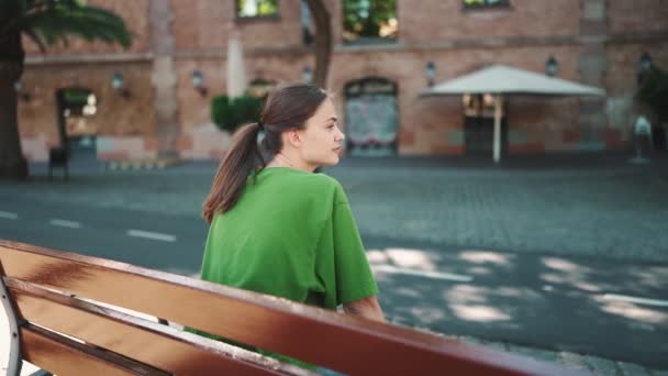 Hezká Blondýnka Zeleném Tričku Sedí Lavičce Městě Venku — Stock video