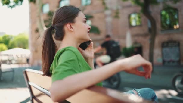 Smiling Blonde Woman Wearing Green Shirt Talking Mobile Looking Bench — Stock Video