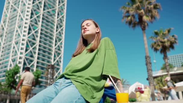 Relaxed Blonde Woman Wearing Green Shirt Looking Drinking Orange Juice — Stock Video