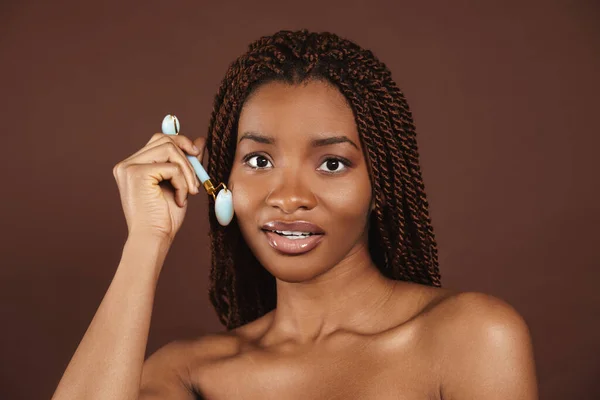 Half Naked Black Woman Massaging Face Jade Roller Isolated Brown — Stock Photo, Image