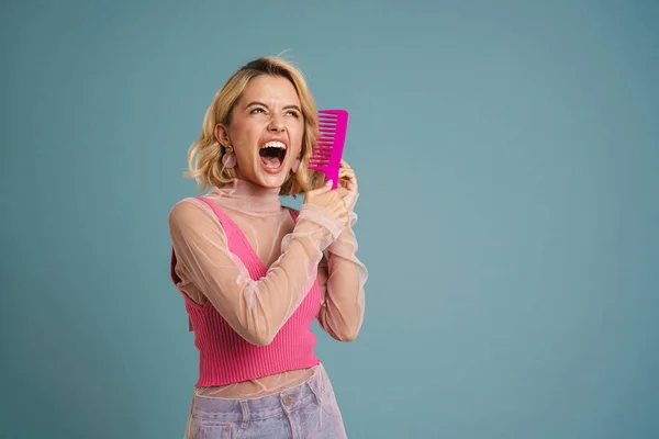 Jovem Mulher Branca Gritando Enquanto Penteia Seu Cabelo Loiro Isolado — Fotografia de Stock