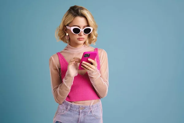 Ung Vit Kvinna Solglasögon Med Mobiltelefon Isolerad Över Blå Vägg — Stockfoto