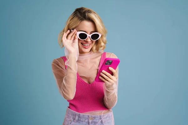 Ung Hvit Kvinne Solbriller Smiler Mens Hun Bruker Mobiltelefon Isolert – stockfoto