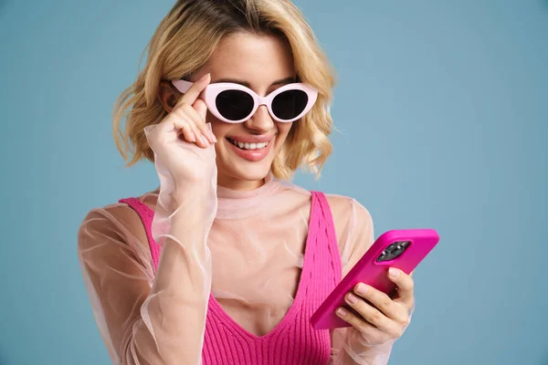Молодая Белая Женщина Солнечных Очках Улыбается Используя Мобильный Телефон Изолирован — стоковое фото