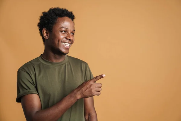 Jonge Zwarte Man Draagt Shirt Lachend Wijzend Vinger Opzij Geïsoleerd — Stockfoto