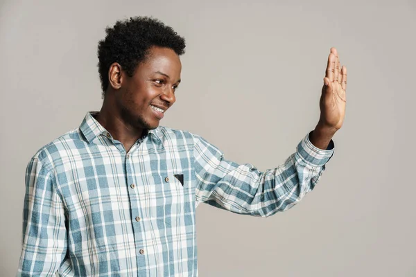 Zwarte Man Geruite Shirt Zwaaiende Hand Terwijl Lachend Opzij Geïsoleerd — Stockfoto