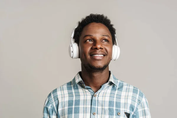Schwarzer Mann Lächelt Während Musik Mit Kopfhörern Auf Weißem Hintergrund — Stockfoto
