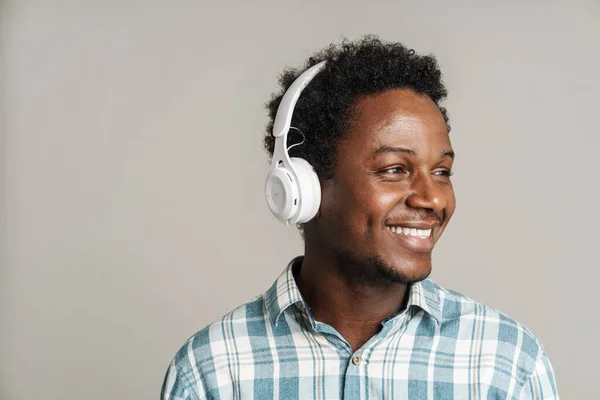 Junger Schwarzer Mann Lächelt Während Musik Mit Kopfhörer Auf Weißem — Stockfoto