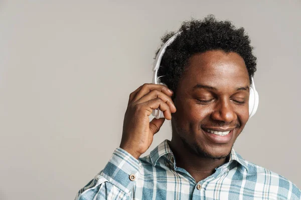 Молодой Черный Человек Улыбается Время Прослушивания Музыки Наушниками Изолированы Белом — стоковое фото