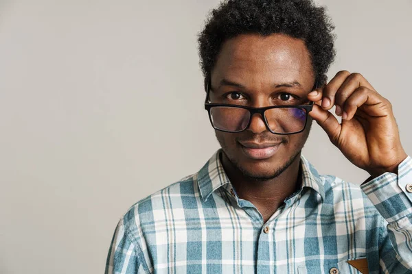 年轻的黑人男人戴着眼镜 面带微笑 看着被白色背景隔离的相机 — 图库照片